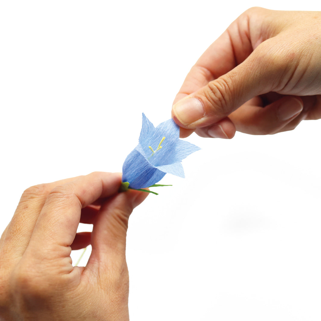 photo packshot de l'étape de mise en forme d'une clochette de campanule du kit bouquet de campanules en crépon dans les tons bleu violet, bleu ciel, jaunes, ivoire, magenta et vert moyen adeline klam