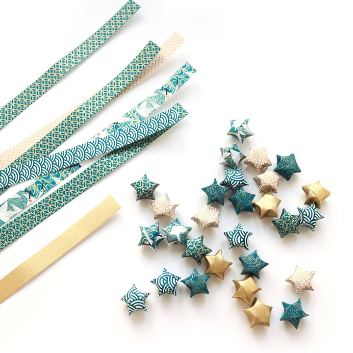 photo packshot des étoiles et des bandelette de papier japonais du kit guirlande d'étoiles en origami bleu canard, blanc et doré « orient » adeline klam