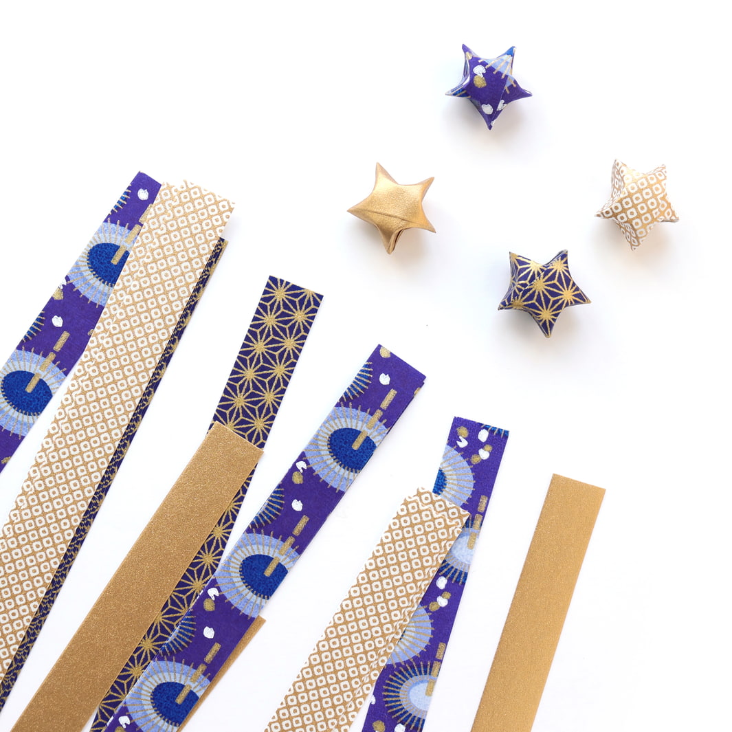 photo packshot des étoiles montées et des bandelettes de papiers japonais du kit étoiles en origami dans les tons bleu nuit, dorés et blanc « céleste » adeline klam