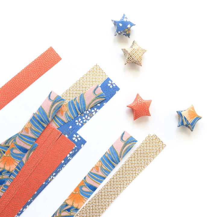 photo packshot des étoiles montées et des bandelettes de papiers japonais du kit étoiles en origami dans les tons corail, bleu pervenche, roses et dorés « william » adeline klam