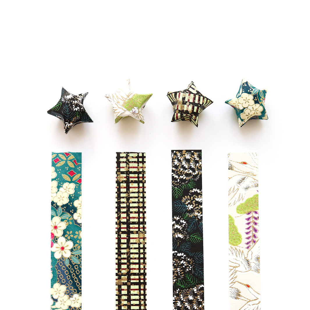 photo packshot des étoiles montées et des bandelettes de papiers japonais du kit étoiles en origami dans les tons noir, bleu canard, blanc nacré et dorés « chaplin » adeline klam