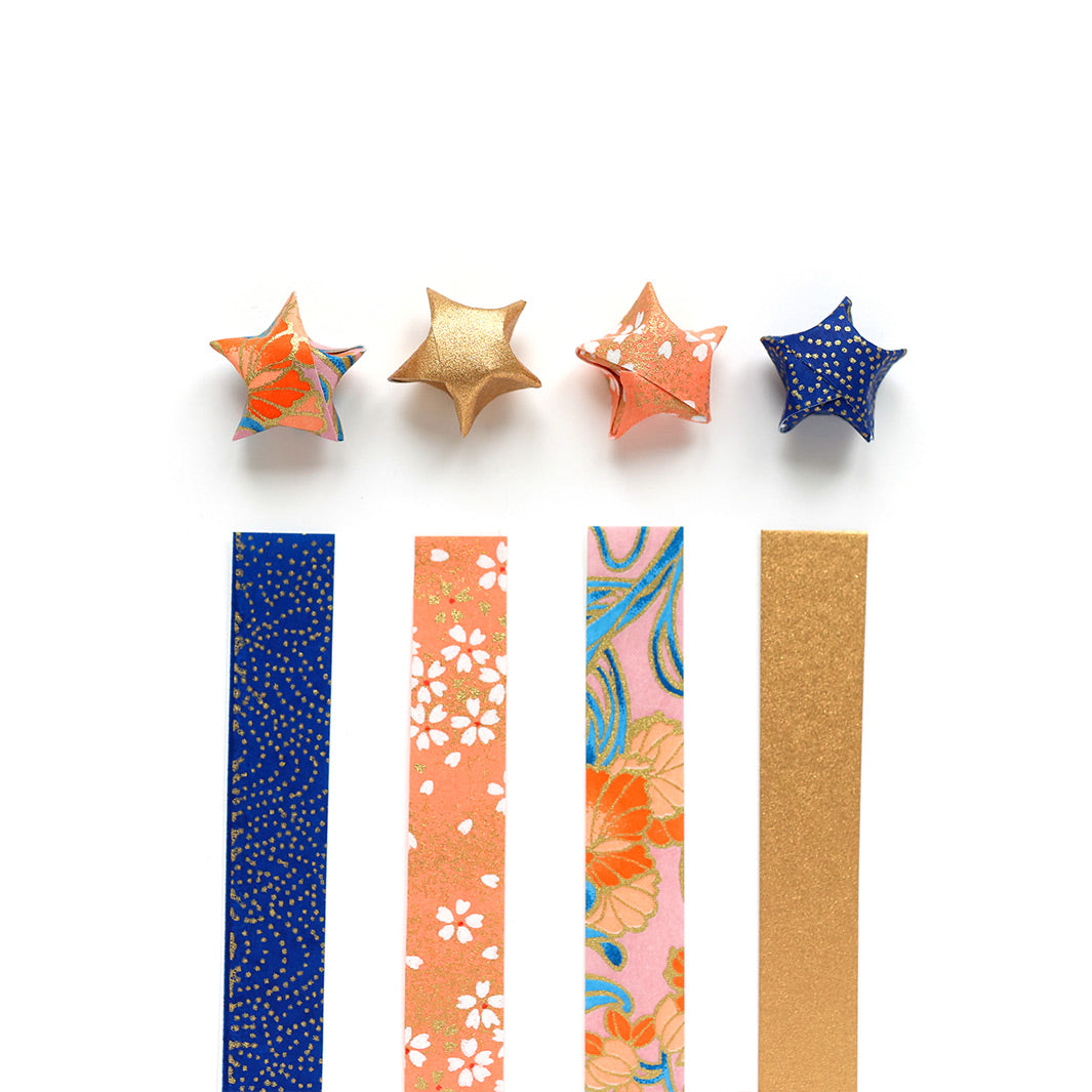 photo packshot des étoiles montées posées droites du kit étoiles en origami « william » dans les tons corail, bleu moyen, bleu nuit, bois de rose et dorés adeline klam