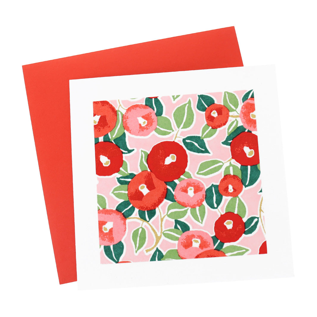 photo packshot vue de face de la carte carrée double habillée d'un carré de papier japonais de 13cm aux motifs de camélias dans les tons rouges, roses et verts (M722) et son enveloppe rouge adeline klam