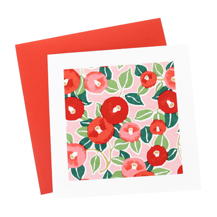 photo packshot vue de face de la carte carrée double habillée d'un carré de papier japonais de 13cm aux motifs de camélias dans les tons rouges, roses et verts (M722) et son enveloppe rouge adeline klam