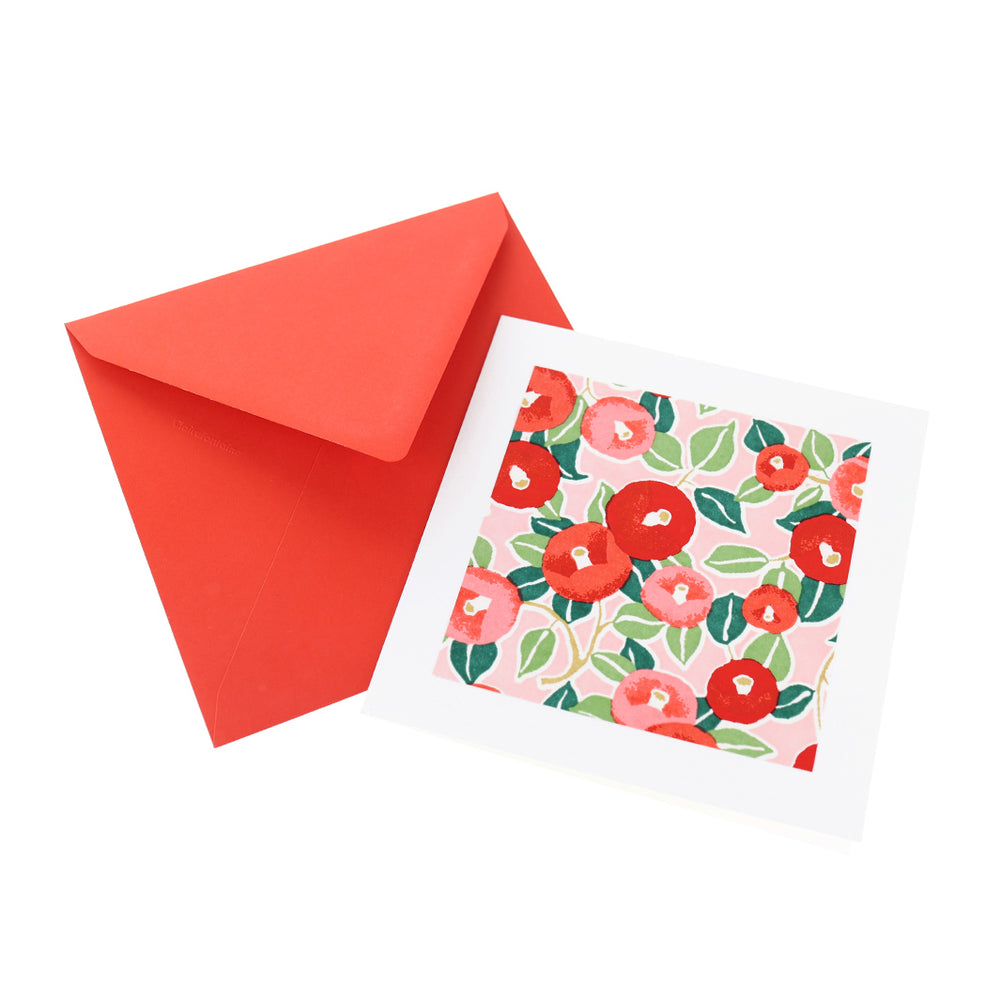 photo packshot vue de face de la carte carrée double habillée d'un carré de papier japonais de 13cm aux motifs de camélias dans les tons rouges, roses et verts (M722) et son enveloppe rouge adeline klam