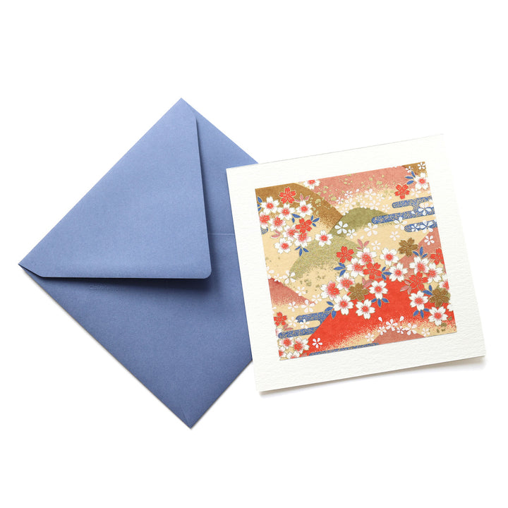photo packshot vue de face de la carte carrée double habillée d'un carré de papier japonais de 13cm au motifs de montagnes et de fleurs de cerisier dans les tons jaunes, orange, verts et bleus (M761) et son enveloppe assortie adeline klam