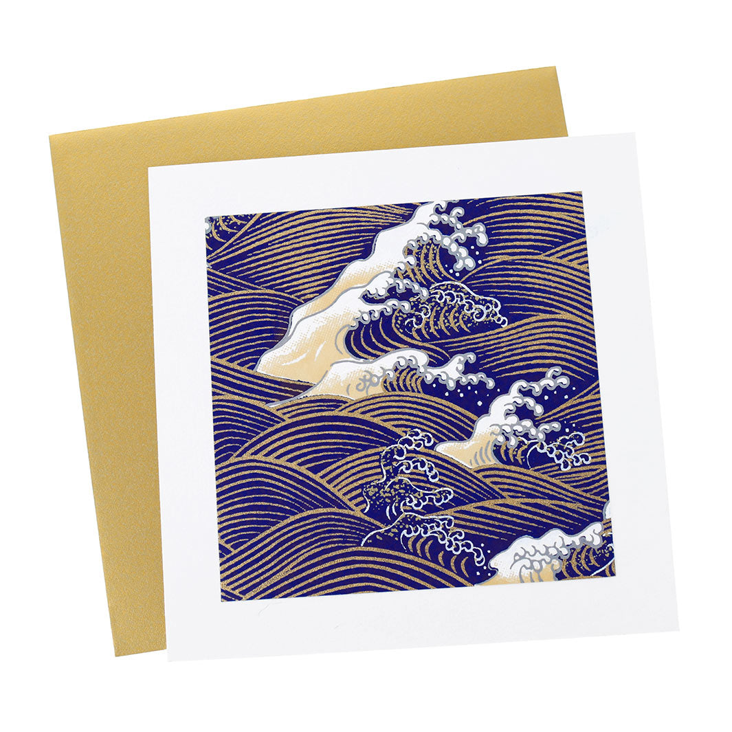 photo packshot vue de face de la carte carrée double habillée d'un carré de papier japonais de 13cm aux motifs de vagues et d'écumes dans les tons bleu nuit, jaune clair et doés (M851) et son enveloppe dorée adeline klam