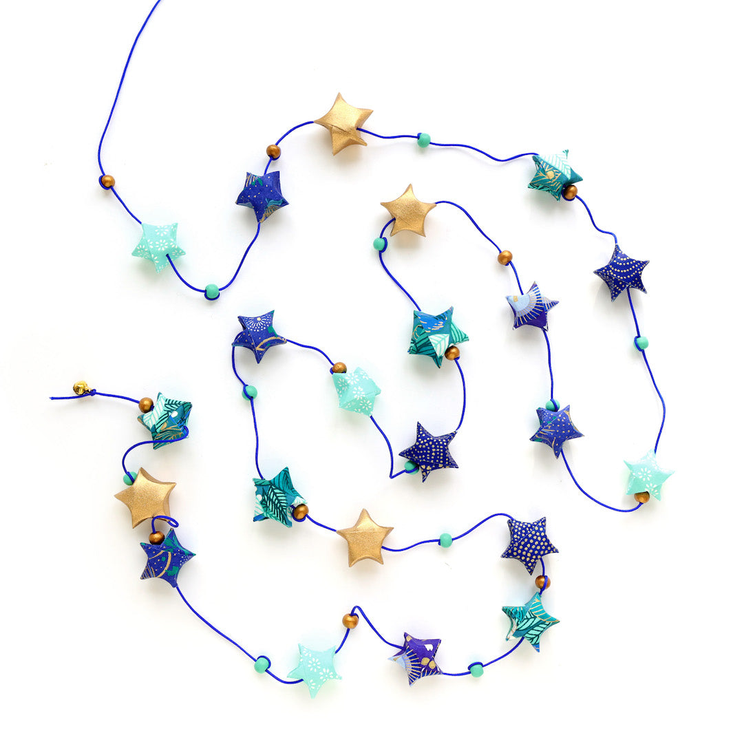 photo packshot de la guirlande montée du kit guirlande d'étoiles en origami bleu nuit, bleu turquoise, vert, vert d'eau et doré « libellule » adeline klam