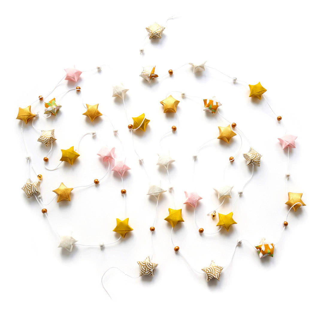 photo packshot de la guirlande montée du kit guirlande d'étoiles en origami jaune moutarde, rose clair et blanc « savane » adeline klam