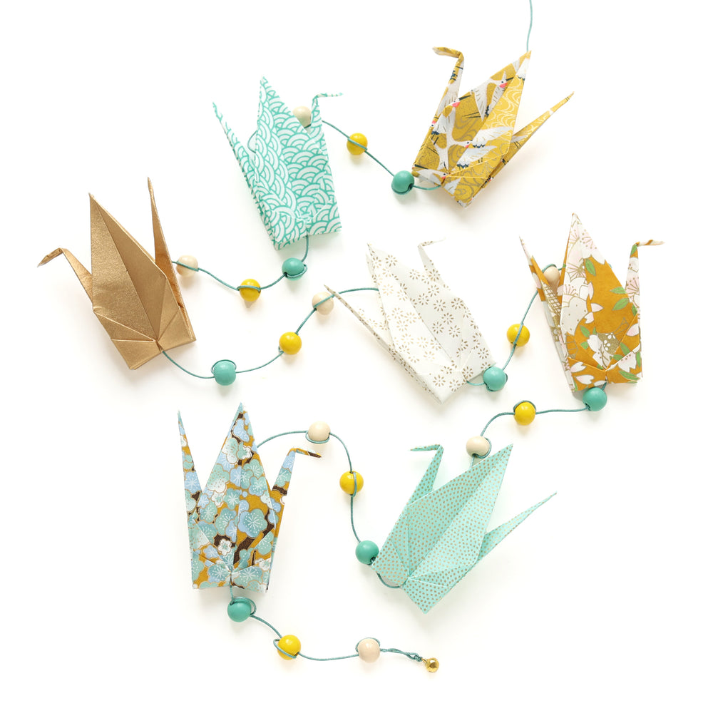 photo packshot de la guirlande montée du kit guirlande de grues en origami dans les tons jaune moutarde, jaune caramel, vert d'eau, vert menthe et dorés de la gamme « pollen » (U9) adeline klam