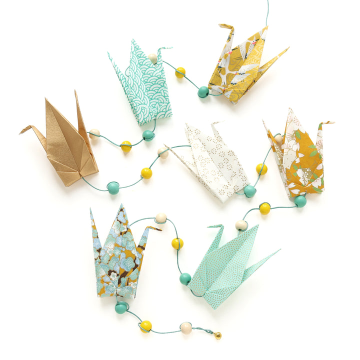 photo packshot de la guirlande montée du kit guirlande de grues en origami dans les tons jaune moutarde, jaune caramel, vert d'eau, vert menthe et dorés de la gamme « pollen » (U9) adeline klam