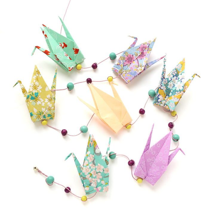 photo packshot de la guirlande montée du kit guirlande de grues en origami dans les tons vert d'eau, vert menthe, jaune moutarde et orange pastel de la gamme « confiserie » (K12) adeline klam