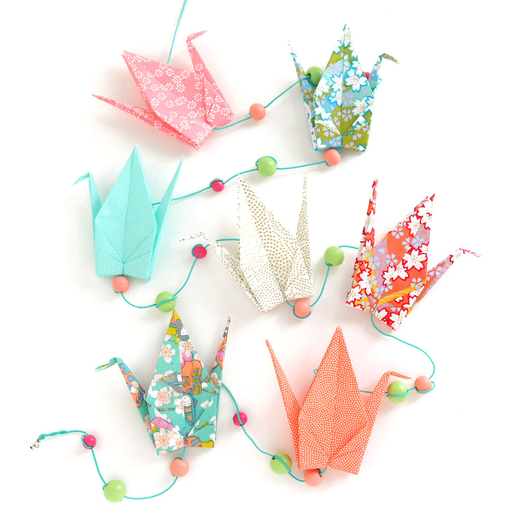 photo packshot de la guirlande montée du kit créatif guirlande de grues en origami « floraison » (K10) dans les tons vert menthe, roses, corail et orange adeline klam