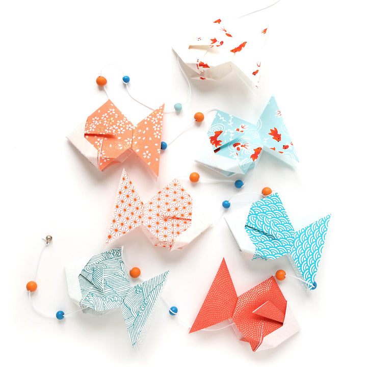 photo packshot de la guirlande montée du kit guirlande de poissons en origami dans les tons bleu ciel, turquoise, corail, rouges et oranges de la gamme « sunset » adeline klam