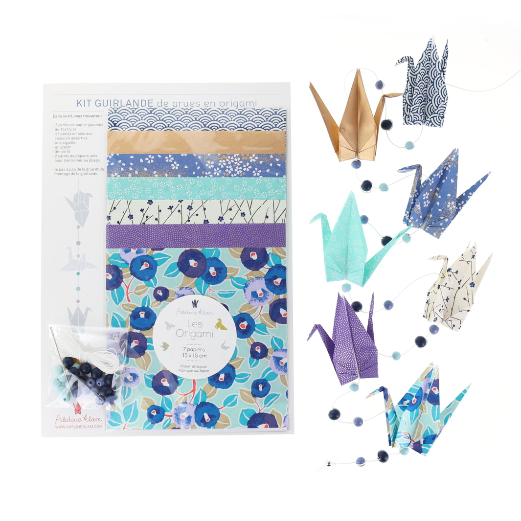 photo packshot de la guirlande montée et du packaging du kit créatif guirlande de grues en origami « fraîcheur » (Z14) dans les tons bleu marine, nuit et pervenche, vert d'eau et dorés adeline klam