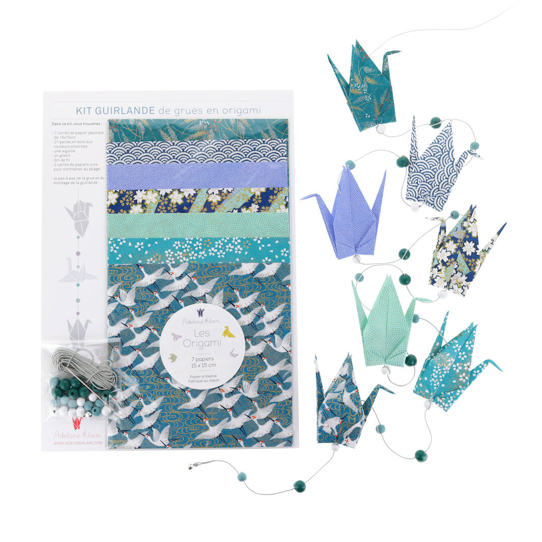 photo packshot de la guirlande montée et du packaging du kit créatif guirlande de grues en origami « orage » (Z11) dans les tons bleu nuit, bleu canard et vert d'eau adeline klam