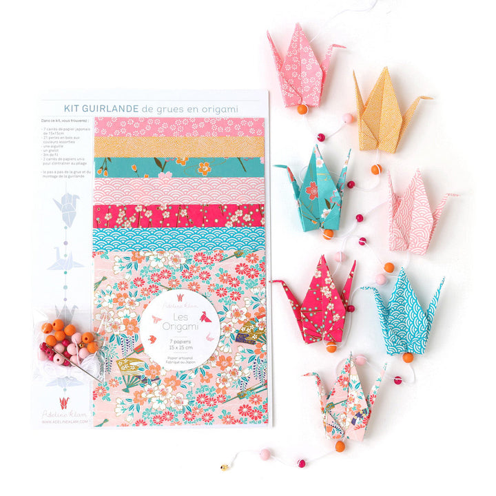 photo packshot de la guirlande montée et du packaging du kit créatif guirlande de grues en origami « roudoudou » (A11) dans les tons roses, jaune orangé et bleu turquoise adeline klam