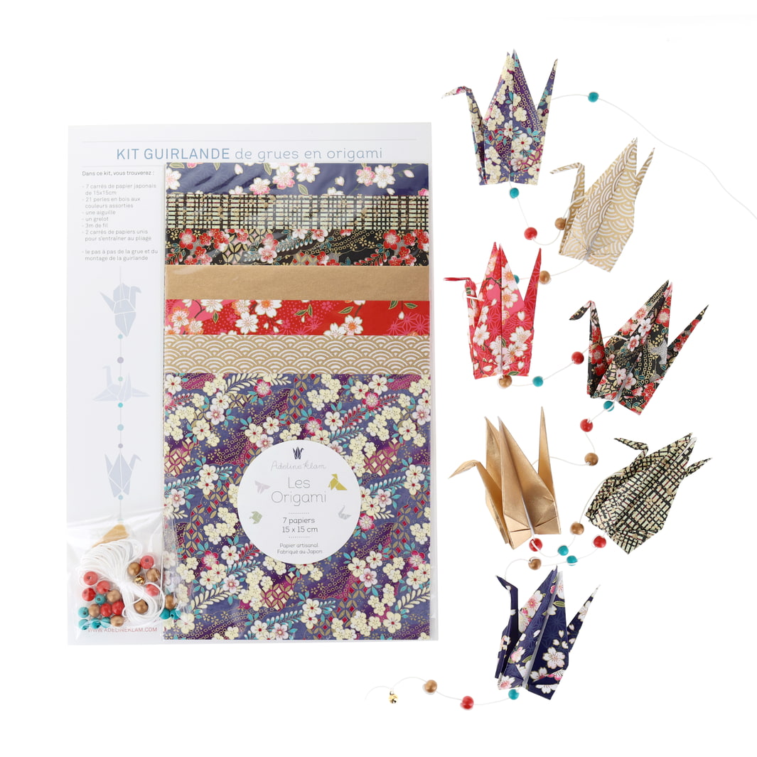 photo packshot de la guirlande montée et du packaging du kit créatif guirlande de grues en origami « obachan » (J7) dans les tons violet foncé, noirs, rouge carmin et dorés adeline klam