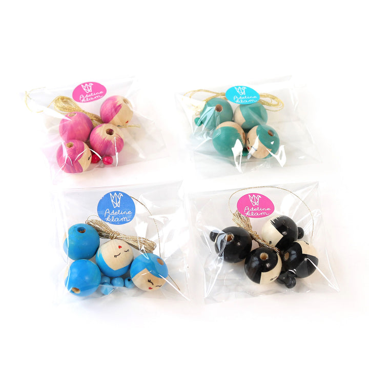 photo packshot des lots de fil et de perles « poupées kokeshi » roses, vertes, bleues et noires adeline klam
