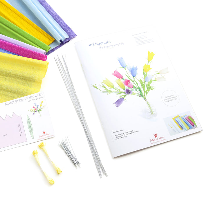 photo packshot du manuel fermé et des fournitures du kit bouquet de campanules en crépon dans les tons bleu violet, bleu ciel, jaunes, ivoire, magenta et vert moyen adeline klam