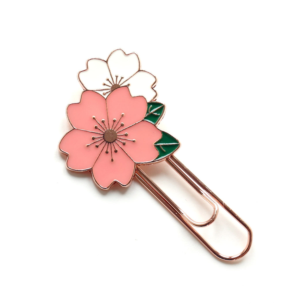 photo packshot du marque-page trombone or rose décoré de fleurs de cerisier roses et blanches aux feuillages verts