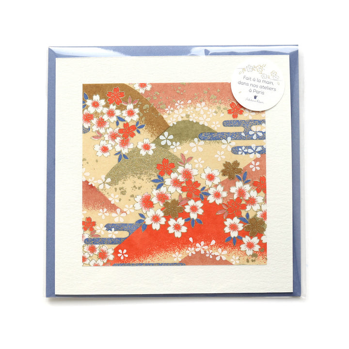 photo packshot du packaging de la carte carrée double habillée d'un carré de papier japonais de 13cm au motifs de montagnes et de fleurs de cerisier dans les tons jaunes, orange, verts et bleus (M761) et son enveloppe assortie adeline klam