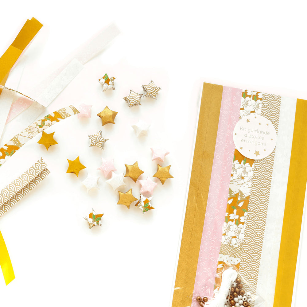 photo packshot du packaging, des étoiles et des bandelette de papier japonais du kit guirlande d'étoiles en origami jaune moutarde, rose clair et blanc « savane » adeline klam