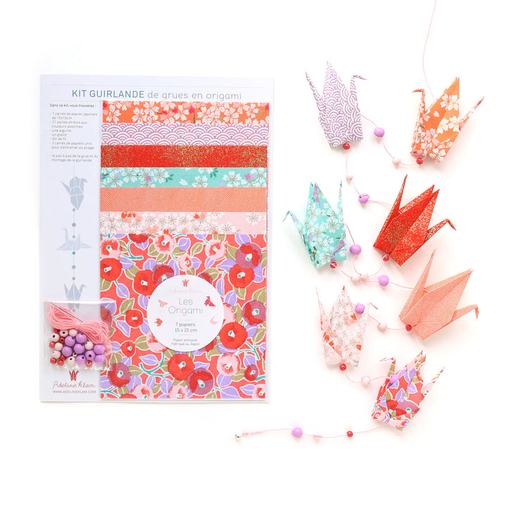 photo packshot du packaging et de la guirlande montée du kit guirlande de grues en origami dans les tons rouge rose, violet mauve, orange pastel et vert menthe de la gamme « hibiscus » (C9) adeline klam