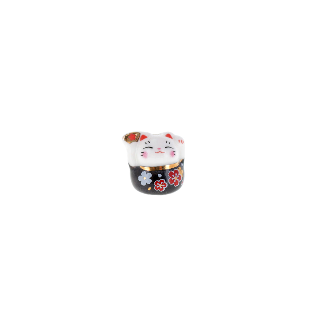 photo packshot de face de perle en céramique en forme de petit maneki-neko noir portant un éventail