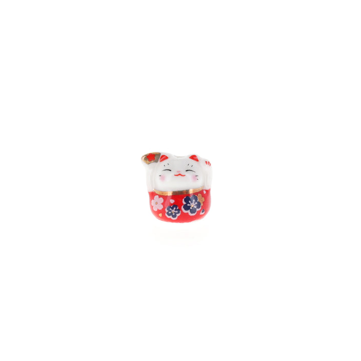 photo packshot de face de perle en céramique en forme de petit maneki-neko rouge portant un éventail