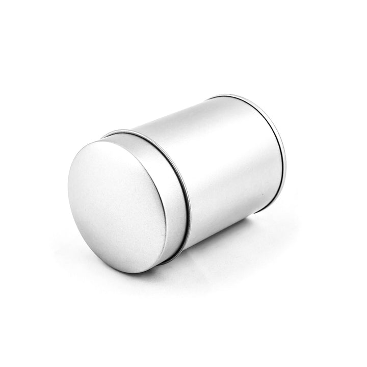 photo packshot de la petite boîte à thé ou à épices couchée au couvercle simple bombé fermé