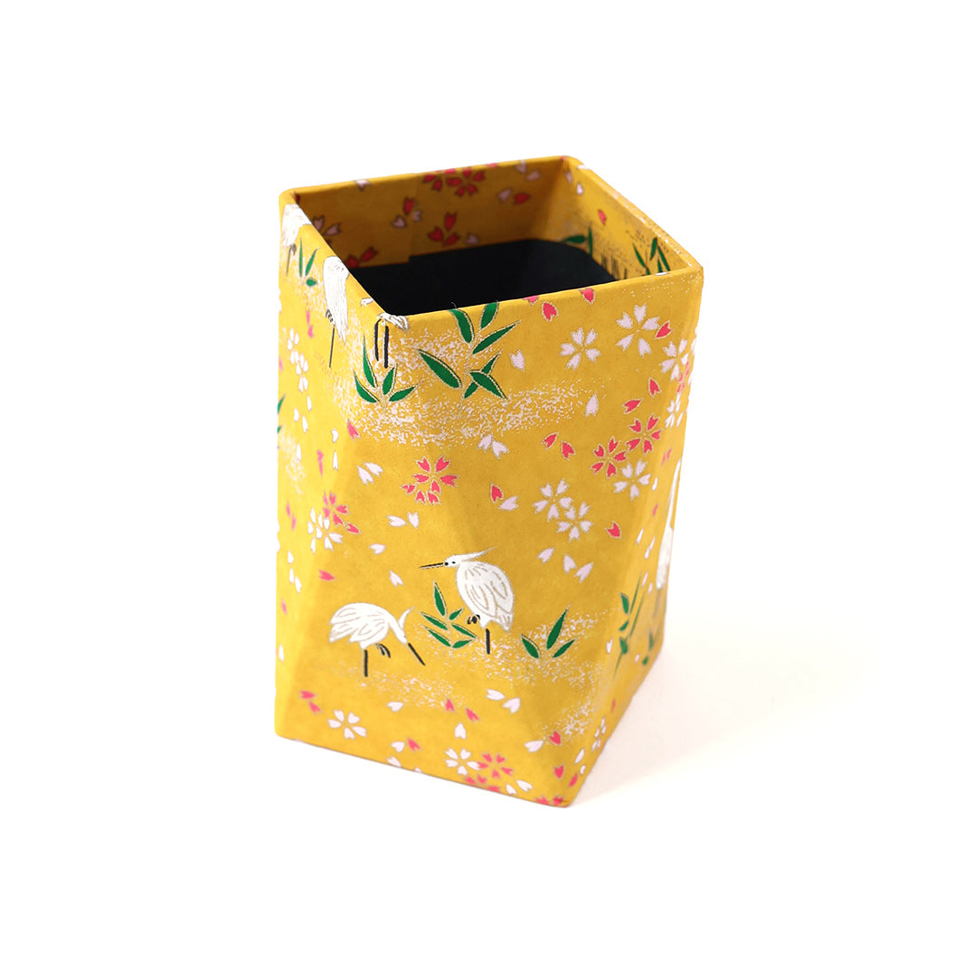 photo packshot du pot à crayon prisme habillé d'un papier japonais aux motifs de hérons et de fleurs sur fond jaune moutarde adeline klam (M659)