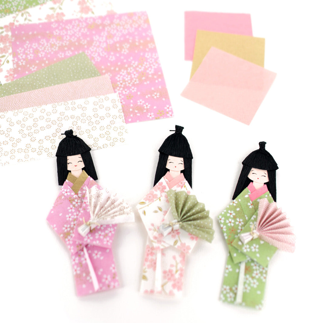 photo packshot des poupées montées et du matériel du kit poupées japonaises « hina matsuri » dans les tons roses, verts, blancs et dorés adeline klam