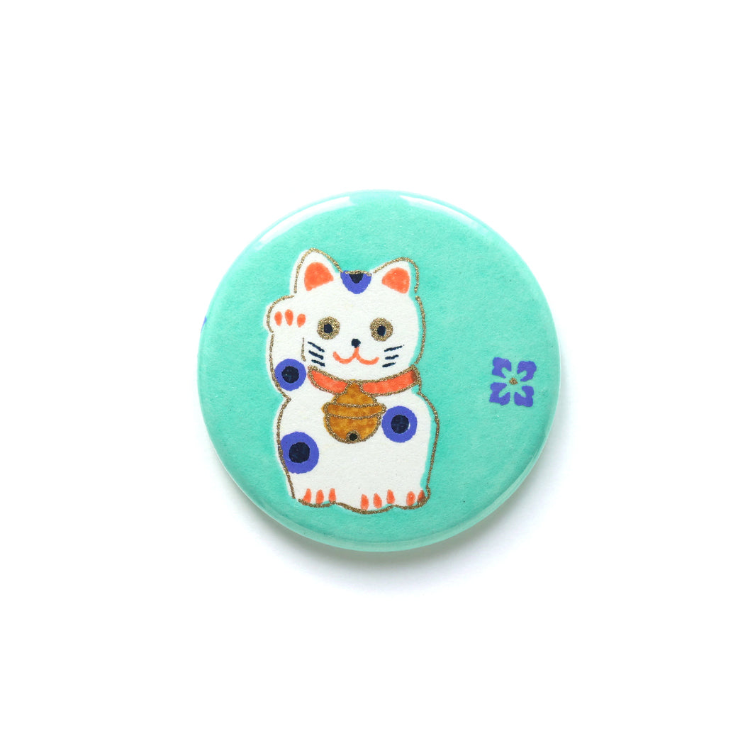 photo packshot du recto de l'aimant en papier japonais de 45mm de diamètre aux motifs de maneki-neko blancs aux détails orange et bleu violet sur fond vert menthe (M838) adeline klam