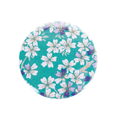 photo packshot du recto du miroir de poche tapissé de papier japonais aux motifs de fleurs de cerisier dans les tons bleu turquoise, bleu marine, gris violet et blanc M625 adeline klam