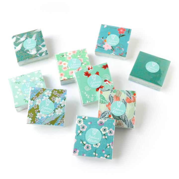 photo packshot de sets de 100 carrés de papiers japonais adeline klam de 6cm par 6cm dans les tons vert clair et foncé, vert d'eau, menthe et bleu turquoise « garden »