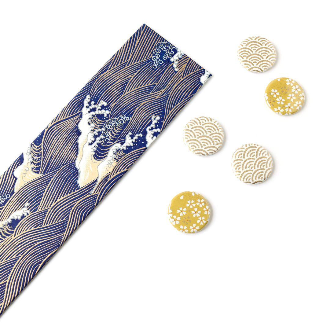 photo packshot avec une vue de biais du pêle-mêle tapissé du papier japonais aux motifs de vagues et d'écumes dans les tons bleu nuit, jaune clair et dorés M851 adeline klam