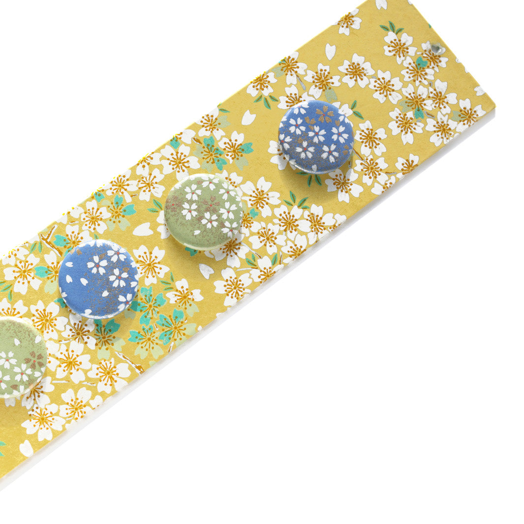 photo packshot avec une vue d'u détail du pêle-mêle tapissé du papier japonais aux motifs de fleurs de cerisier dans les tons blancs, vert d'eau, bleu turquoise et jaune moutarde M578 adeline klam