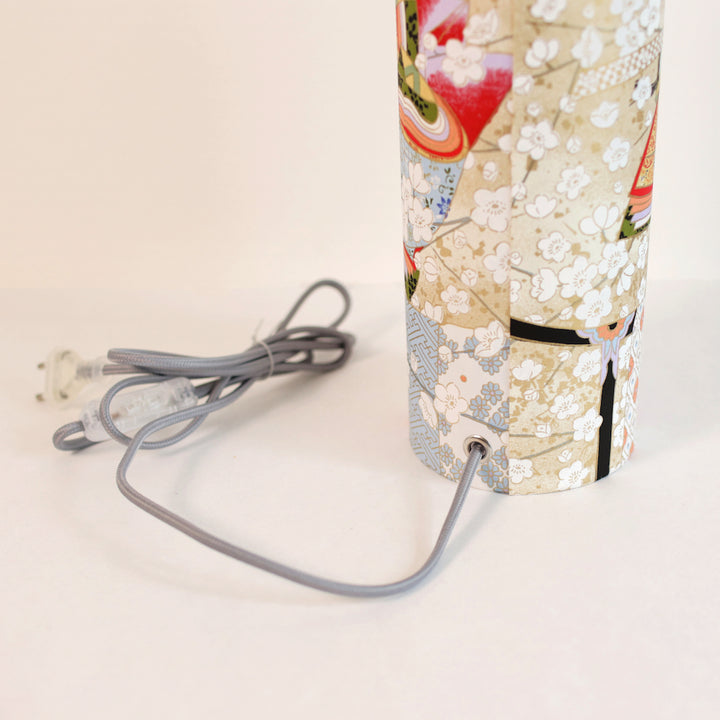 photo packshot avec une vue de face d'un détail du câble électrique gris d'une lampe à poser japonaise (taille s) au motif de femmes en kimono dans les tons mordorés, rouges, verts, bleus et mauves