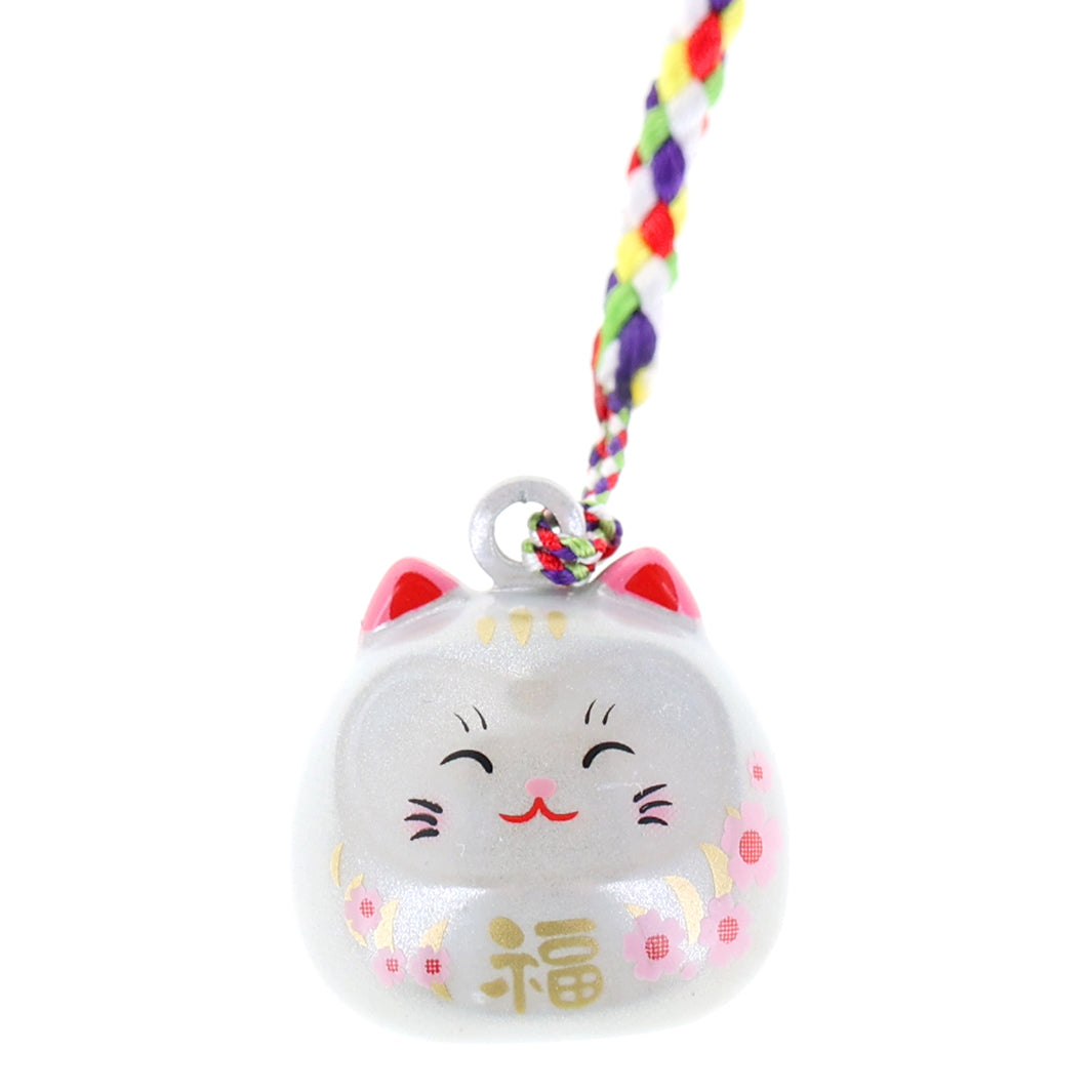 photo packshot zoomée d'un porte-clefs en forme de daruma et de chat de couleur blanc nacré