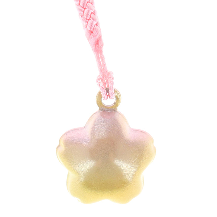 photo packshot zoomée d'un porte-clefs en forme de fleur de cerisier de couleur jaune et rose nacré