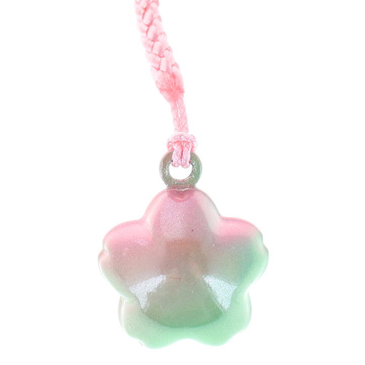 photo packshot zoomée d'un porte-clefs en forme de fleurs de cerisier de couleur vert et rose nacré