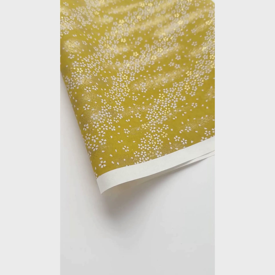 vidéo de démonstration du papier japonais yuzen chiyogami au motif de petites fleurs au vent blanches sur fond jaune moutarde adeline klam (M864)