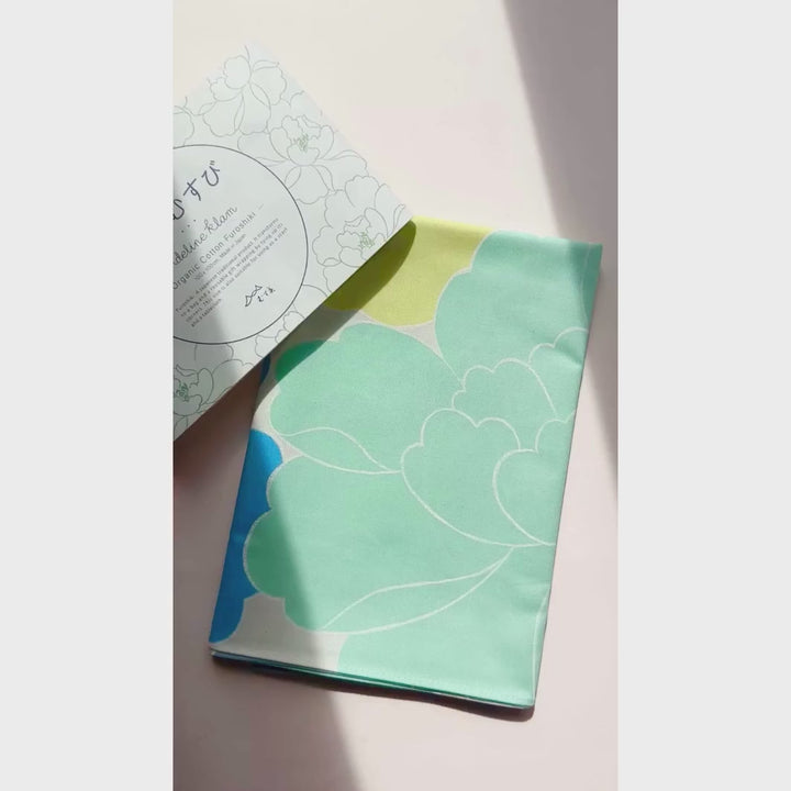 vidéo de démonstration du furoshiki au motif de pivoines dans les tons jaune acidulé, bleus, vert d'eau, violets adeline x musubi en 100cm par 100cm