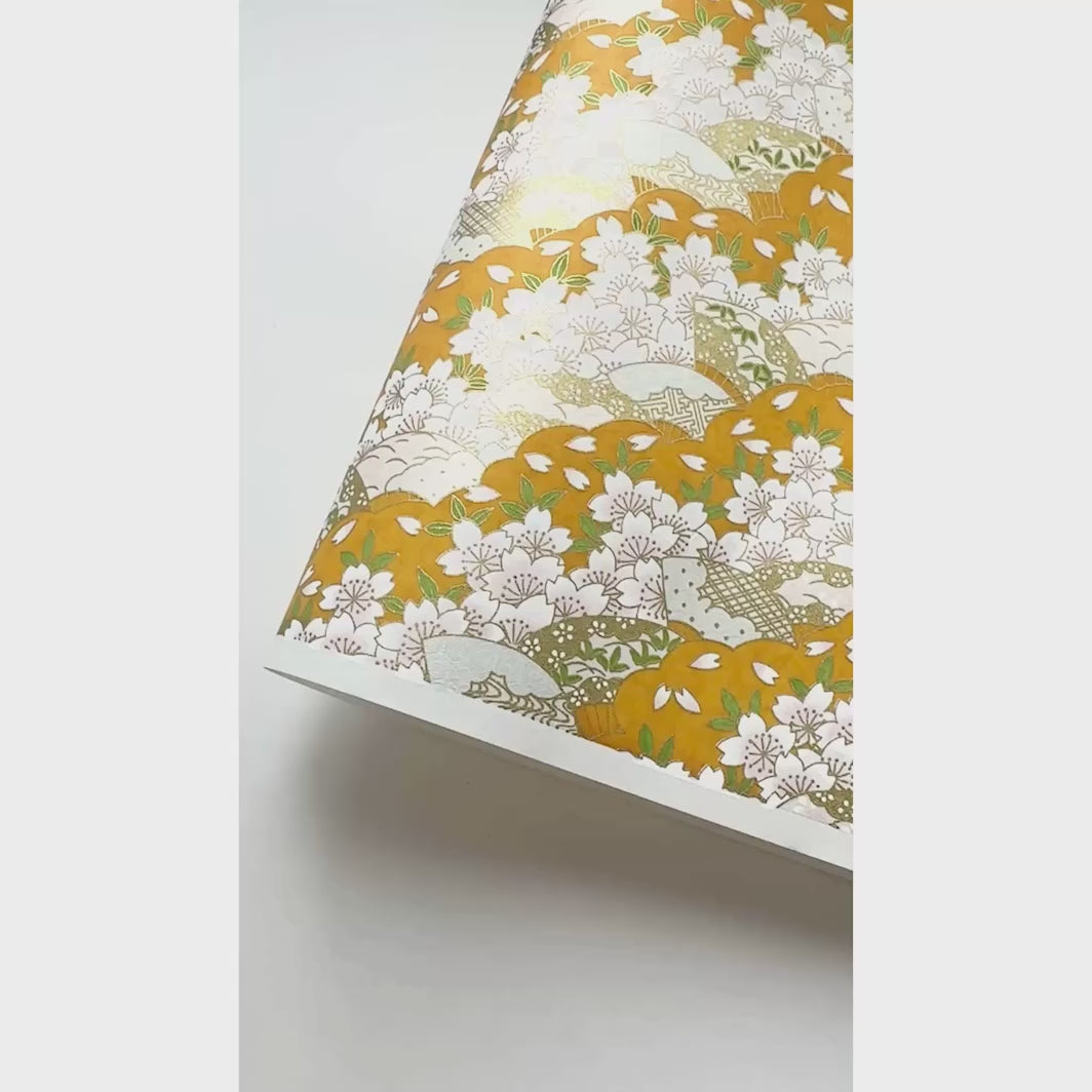 vidéo de démonstration du papier japonais yuzen chiyogami au motif de fleurs de cerisier et d'éventails dans les tons jaune moutarde, blancs, roses et dorés adeline klam (M688)