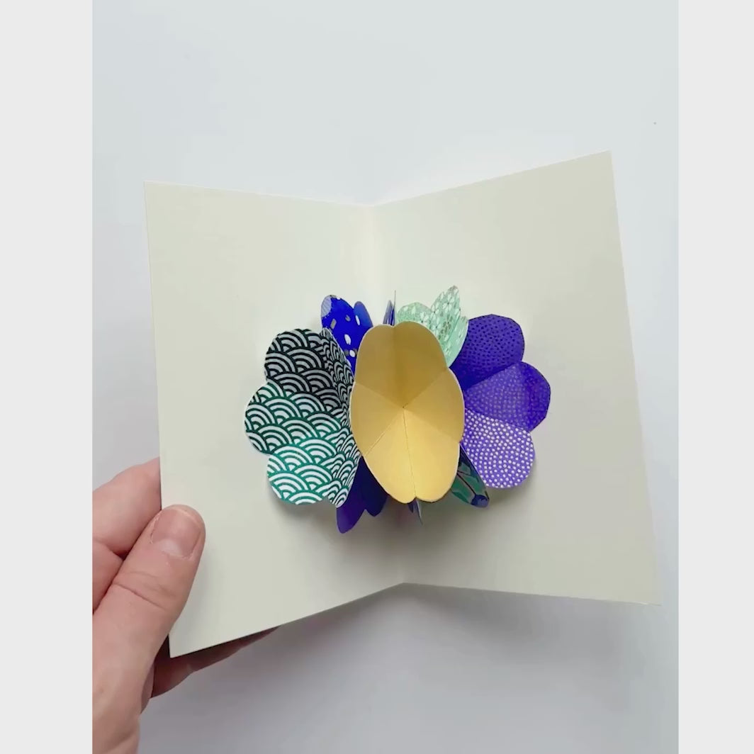 vidéo de démonstration de l'ouverture de la carte du kit 4 cartes pop-up dans les tons vert d'eau, bleu foncé, violets et dorés « fraîcheur » adeline klam