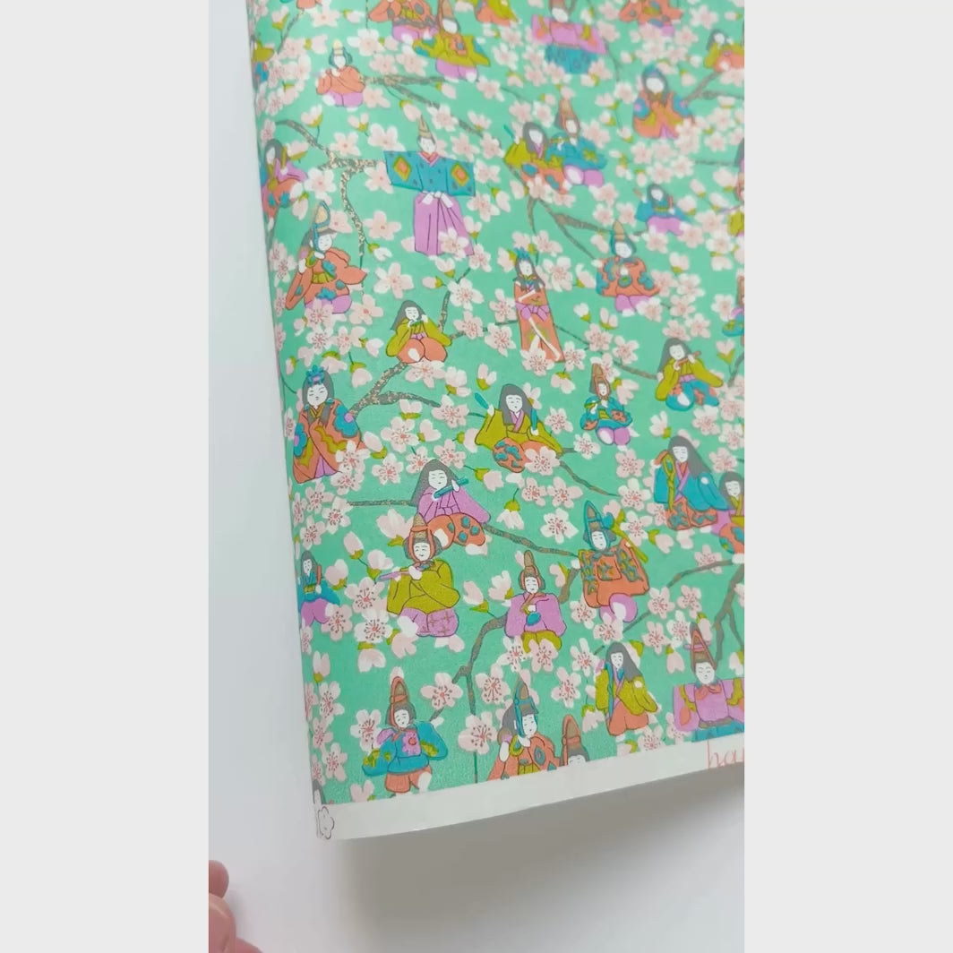 vidéo de démonstration du papier japonais yuzen chiyogami aux motifs de poupées d'hina matsuri et de fleurs de pêcher dans les tons vert menthe, rose, mauve, orange clair, vert acidulé et bleu adeline klam (M1004) 