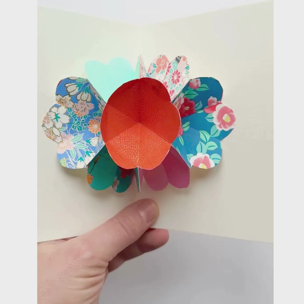 vidéo de démonstration de l'ouverture de la carte du kit 4 cartes pop-up dans les tons bleu turquoise, vert d'eau, roses et rouge orange « lagune » adeline klam