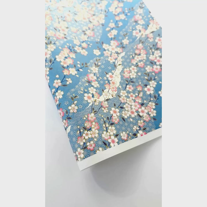 vidéo de démonstration du papier japonais yuzen chiyogami aux motifs de fleurs de cerisier et de moitfs variés dans les tons bleu clair, roses et blancs adeline klam (M384)