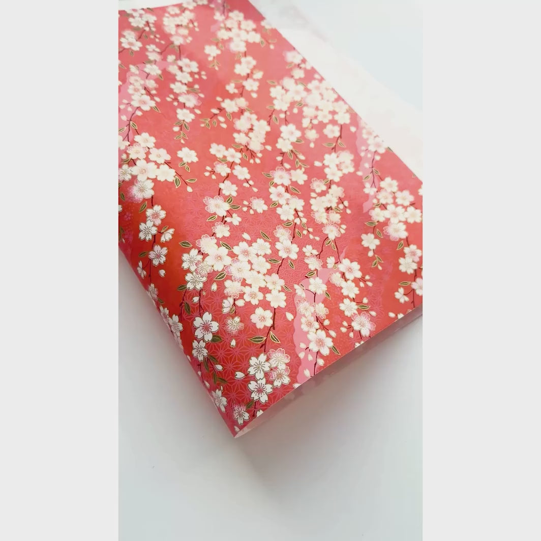 vidéo de démonstration du papier japonais yuzen chiyogami aux motifs de fleurs de cerisier et de motifs variés sur fond rouge orange adeline klam (M385)